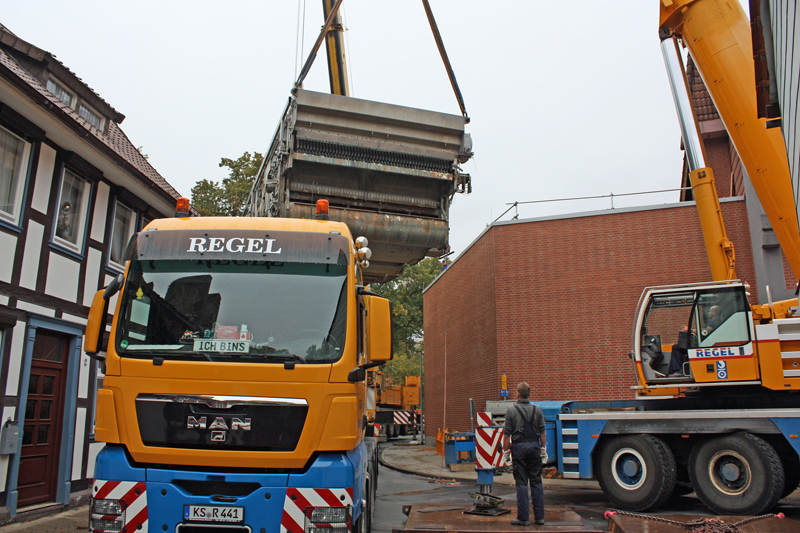 Zwei Autokräne waren notwendig, um die tonnenschwere Maschine aus und in die Halle zu heben.